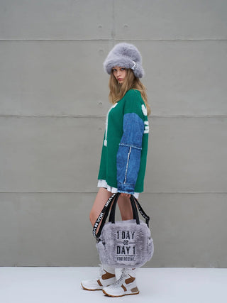 Junge Frau trägt die #VDR Porto Bag grau, eine kuschelige Faux-Fur-Tasche mit schwarzem Schriftzug „1 DAY OR DAY 1 – YOU DECIDE“, kombiniert mit urbanem Winter-Outfit.
