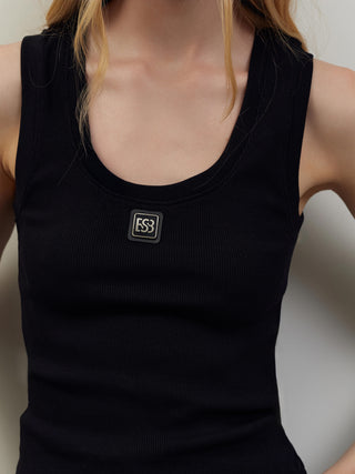 Das BSB Top 210020 black zeigt ein eng anliegendes, geripptes schwarzes Tanktop mit rundem Halsausschnitt und einem kleinen quadratischen Logo-Patch unterhalb des Ausschnitts.