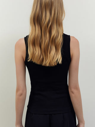 Rückansicht einer Person mit langen, welligen blonden Haaren in einem ärmellosen, schwarzen BSB Top 210020, das eine Rippstruktur und einen figurbetonten Schnitt aufweist.