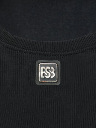 Nahaufnahme des BSB Top 210020 black, zeigt den gerippten, schwarzen Stoff mit einem kleinen, quadratischen Metallabzeichen ESS. unterhalb des Rückenausschnitts.
