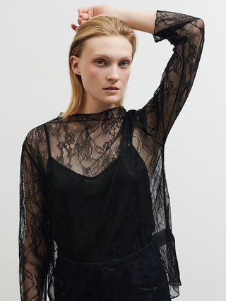 Frau trägt BSB Bluse 210065 black, eine transparente schwarze Spitzenbluse mit floralen Mustern, über einem schwarzen Top. Langärmlig und gerade geschnitten, verleiht sie dem Look eine elegante Note.