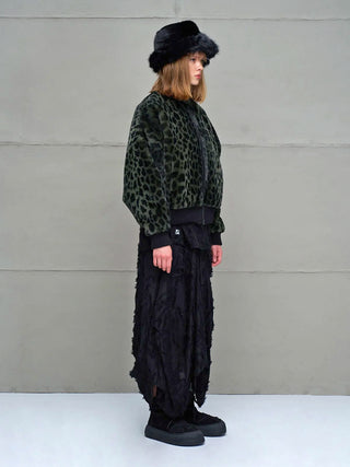 Junge Person in #VDR Jacke green/black, ein dunkler, leoparden-gemusterter Faux-Fur-Bomber mit Oversized-Schnitt und Retro-Vibe, kombiniert mit einem asymmetrischen schwarzen Rock und klobigen Plattform-Sneakern.