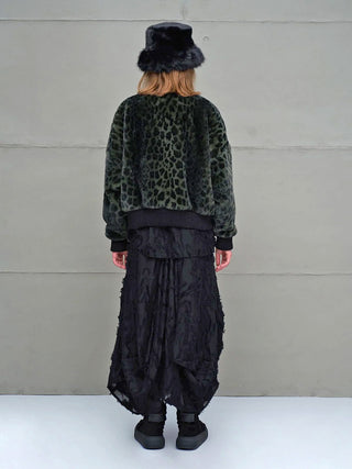 Person von hinten in #VDR Jacket green/black, einer dunklen, olivgrünen Leopard-Bomberjacke aus Kunstpelz, kombiniert mit einem schwarzen, flauschigen Hut und einem langen, schwarzen Rock.