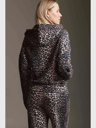 Eine Person trägt die Cotton Candy Maja Jacket multicolor mit einem Leopardenmuster, Kapuze und Reißverschluss, in einer übergroßen Passform. Sie ist von hinten zu sehen, in einem Studio.