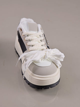 OFF#DLY Sneaker Diana white black mit hochgezogener, zweifarbiger Sohle, weißem Zehenbereich, grauen Wildleder-Overlays, schwarzen Akzenten, flauschigem Innenfutter und dekorativem Metall-Detail, mit locker gebundenen Schnürsenkeln.