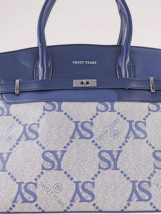 Nahaufnahme der Sweet Years Logo Tote Bag blau beige: Eine Henkeltasche mit blauer Lederbesatz und cremefarbenem Canvas, bedruckt mit SY und SWEET YEARS, inklusive Metall-Drehverschluss.