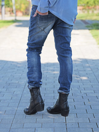 Person trägt OFF#DLY Denim Ines Midblue Destroy, blaue Jeans mit dezenten Destroy-Details. Die Jeans sitzt figurbetont, zeigt eine moderne Waschung und bleibt dank Elasthananteil flexibel.