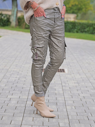OFF#DLY Joggpant Tamara silver in metallisch-oliven Cargo-Stil mit schimmerndem Finish, Flap-Taschen und elastischem Bund, kombiniert mit nudefarbenen Stiletto-Stiefeletten, zeigt urbanen Chic und Bewegungsfreiheit.