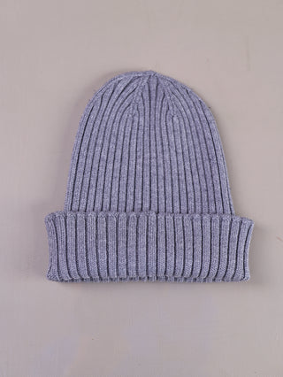 OFF#DLY Mütze Anna grau, eine gerippte Strickmütze mit umgeschlagenem Rand, liegt flach. Materialmix aus Viskose, Polyester und Polyamid, ideal für kühle Tage.