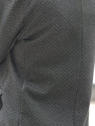 Nahaufnahme des OFF#DLY Blazer Olga grey: Dunkelgraues Gewebe mit dezentem, gesprenkeltem Muster und vertikaler Naht, klassischer Reverskragen, leicht taillierte Passform, hochwertige Materialmischung für zeitlose Eleganz.