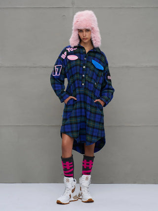 #VDR Shirt 18114 royal/black: Model trägt ein oversized Karohemdkleid mit Patches, halber Knopfleiste, verlängerter Rückseite und Statement-Accessoires. Kombiniert mit Trapperhut, Socken und robusten Stiefeln.