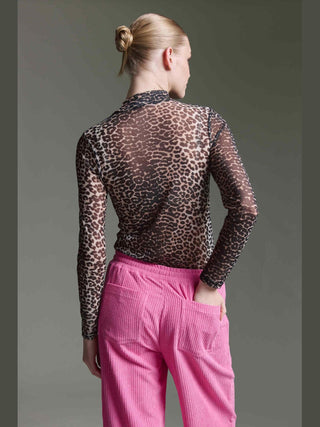 Person von hinten in grauem Hintergrund, trägt Cotton Candy Floortje Tee multicolor, ein langärmeliges, transparentes Leopardenmuster-Oberteil, kombiniert mit auffälligen, pinken Cordhosen mit Gesäßtaschen.
