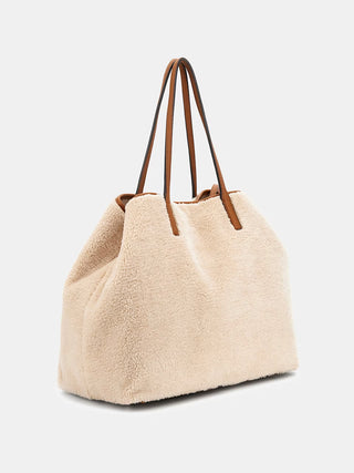 GUESS VICTTORIA LARGE 2 IN 1 TOTE NTC aus cremefarbenem Kunstfell, mit braunen Lederhenkeln, goldfarbenen Metallteilen und Logodreieck. Enthält eine Innenpochette mit Reißverschluss. Maße: 34x40x20 cm.