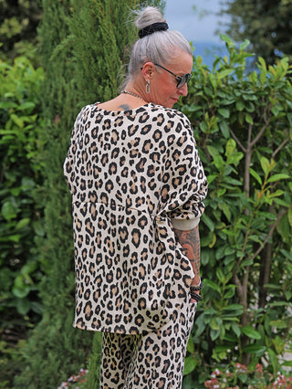 Eine Frau trägt das OFF#DLY Sweat Billie beige/leo, ein lässiges, übergroßes Leopardenmuster-Zweiteiler mit Rundhalsausschnitt, kombiniert mit passenden Hosen für einen stilvollen Alltagslook.