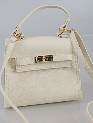 Kleine, strukturierte OFF#DLY Leder Bag creme mit goldfarbenem Drehverschluss, einem oberen Griff, abnehmbarem Schulterriemen und genarbter Ledertextur, präsentiert auf neutralem Hintergrund.