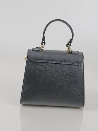 Die OFF#DLY Leder Bag black ist eine kleine, trapezförmige Handtasche aus strukturiertem, schwarzem Leder mit kurzem Griff und goldfarbenen Beschlägen, ideal für stilvolle Auftritte.