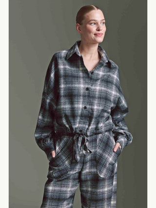 Eine Person trägt die Cotton Candy Bluse Mila multicolor, eine lässige, oversized Karo-Bluse mit Ballonärmeln und Tunnelzug, kombiniert mit passenden, locker geschnittenen Hosen mit großen Fronttaschen.