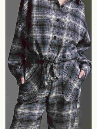 Person trägt Cotton Candy Bluse Mila multicolor mit Ballonärmeln, Tunnelzug und großen Vordertaschen, kombiniert mit lässigen Karo-Hosen, Hände in den Hosentaschen.