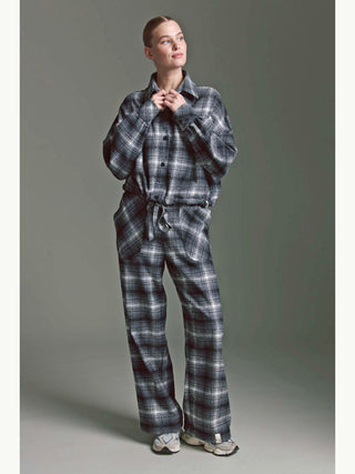 Person trägt die Cotton Candy Bluse Mila multicolor, eine übergroße Karo-Bluse mit Ballonärmeln und Tunnelzug, kombiniert mit passenden Hosen, sowie hellen, klobigen Sneakers.