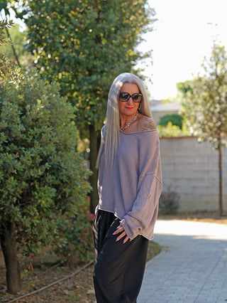 Person trägt den OFF#DLY Pulli Abby grau. Der locker sitzende, off-shoulder Pullover hat weite Ärmel und einen kastigen Schnitt, ideal für lässige, entspannte Looks in der Sonne.