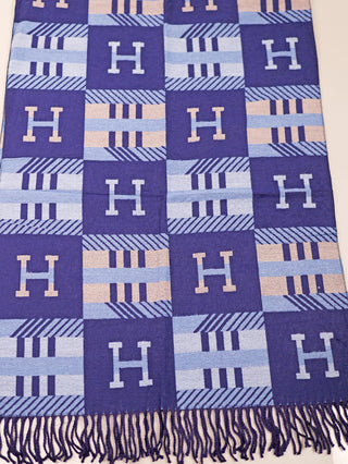 OFF#DLY Schal H blue aus Viskose mit quadratischem Blockmuster aus H- und Streifenmotiven. Navy-, Hellblau- und Pfirsichtöne wechseln sich ab. Unterer Rand mit gedrehten Fransen. Größe 180x65 cm.