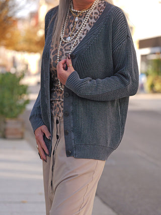 #VDR Cardigan 18074 antra: Locker sitzende Strickweste mit Rippenstruktur und Knopfleiste, über einem Leoparden-Print-Shirt und beigen, hochtaillierten Hosen, verziert mit Perlen- und Goldketten-Halsketten.