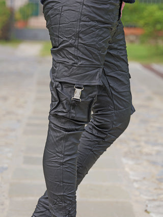 OFF#DLY Joggpant Tamara black matt, zeigt schlanke schwarze Cargohose mit Flap-Taschen und Metallschnallen, leicht zerknitterter Stoff, ideal für urbane Looks und bequeme Passform.