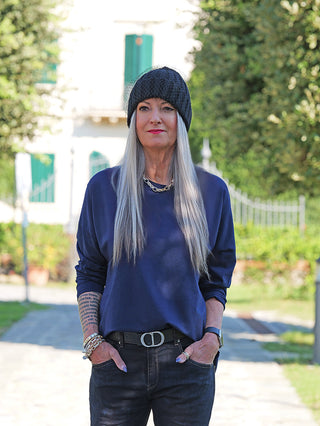 Frau mit silbernem Haar trägt das OFF#DLY Longsleeve Ava darkblue, ein langärmeliges, locker sitzendes Oberteil, kombiniert mit schwarzen Jeans und Accessoires, ideal für einen lässigen Alltagslook.