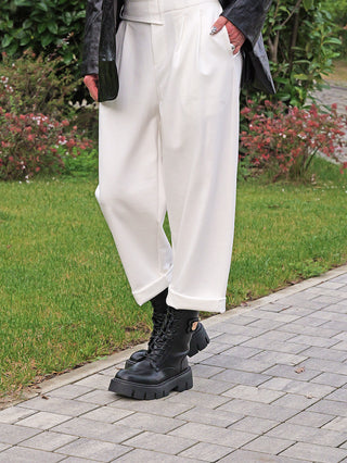 OFF#DLY Hose Moniga white: Locker geschnittene, knöchellange weiße Hose mit asymmetrischem Bund und umgeschlagenem Saum, getragen zu schwarzen Schnürstiefeln, ergänzt durch eine schwarze Lederjacke.