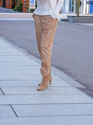OFF#DLY Hose Velourstoff Salo camel: Elegante, camel-farbene Veloursleder-Optik mit glatter Front, seitlichen Taschen und leicht lockerer Passform, kombiniert mit passenden spitzen Stiefeletten auf gepflastertem Gehweg.