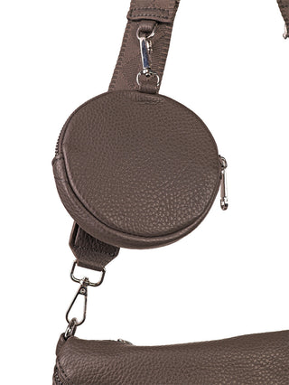 Nahaufnahme des Paolo Bag Crossbag grey mit braunem, genarbtem Lederband und abnehmbarer, runder Reißverschlusstasche sowie einem Blick auf die obere Kante der passenden größeren Tasche.