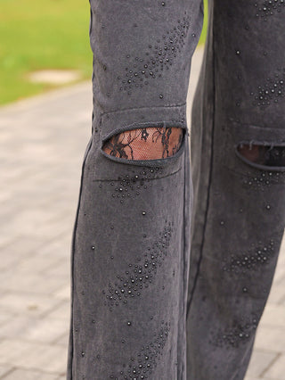 OFF#DLY Joggingpant Glitzer Destroy black zeigt dunkle, mit Glitzer verzierte Jogginghose, distressed am Knie mit sichtbarer Spitze darunter, für einen modischen, rockigen Look.