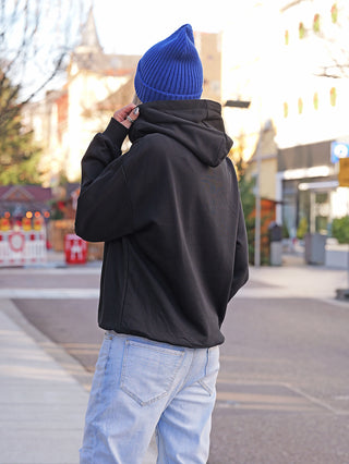 Person in urbaner Umgebung trägt den OFF#DLY Sweat DOG black Hoodie mit humorvollem Hunde-Print und 3D-Mützen-Detail, passend zu lässigem Streetstyle.