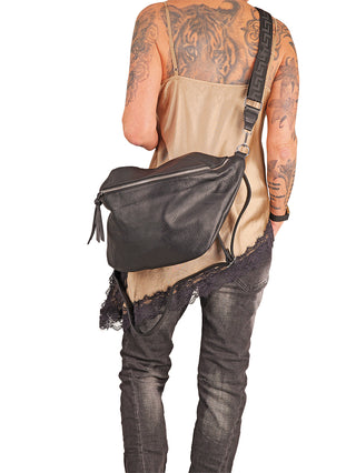 Person von hinten mit OFF#DLY Big Crossbody black, einer großen, schwarzen Umhängetasche mit Reißverschluss und verstellbarem Trageriemen, getragen über einem lockeren Camisole-Top und Jeans.