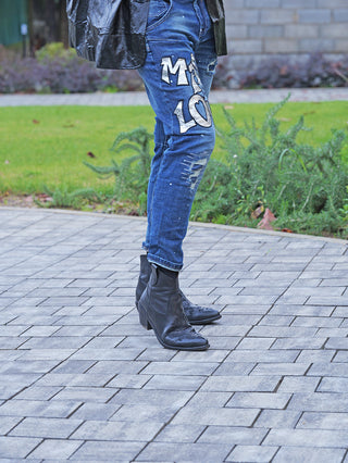 OFF#DLY Destroy Denin Star midblue Jeans mit auffälligem M LOVE-Print und umgeschlagenen Bündchen, getragen zu schwarzen Stiefeletten.