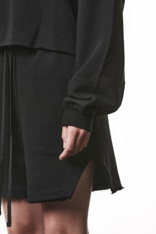 Thom Krom WS496 Sweat black: Schwarzer Sweater mit gerippten Ärmelbündchen und offenem Saum über einem Rock oder Shorts, betont moderne, lässige Passform und avantgardistischen Stil.