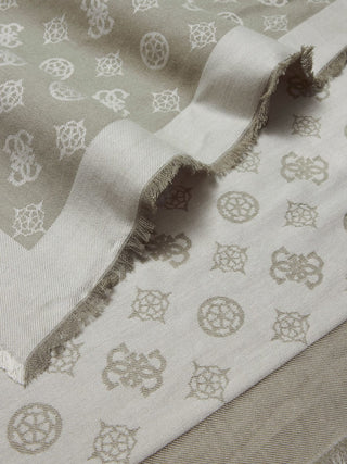 Nahaufnahme des GUESS Prited Kefiah THY, ein gefaltetes Textil mit Jacquard-Muster aus runden Medaillons und geometrischen Formen. Die selvedge-Kanten sind leicht ausgefranst. Material: 100% Viskose.