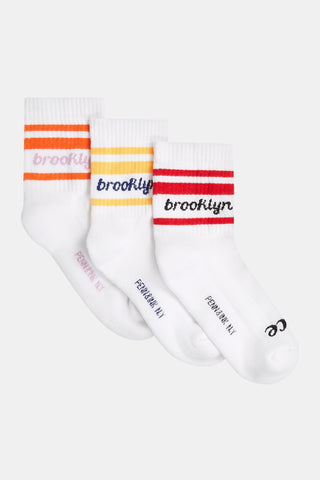 Penn&Ink Socks 3 Pack 1855 multicolor zeigt drei weiße Crew-Socken mit farbigen Streifen und brooklyn-Schriftzug. Unterhalb des Bogens steht PENN AVE NY. Retro-Design für sportlichen Stil.