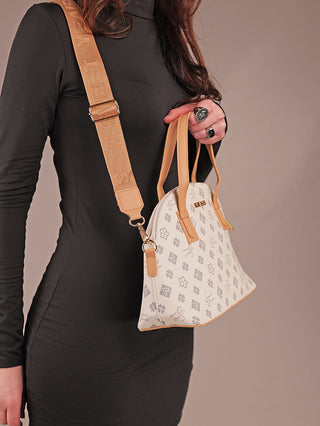 Person hält eine Sweet Years Bag 68 grey, eine strukturierte weiße Handtasche mit hellbraunen Lederdetails und dezentem grauen Motiv, passend zur schwarzen, figurbetonten Langarmkleid.
