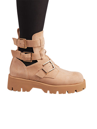 OFF#DLY Summer Boot beige, ein Damenstiefel aus weichem Velours mit breiten Riemen und goldenen Schnallen, auf einer klobigen, geriffelten Gummisohle, passend zu schwarzen Leggings.