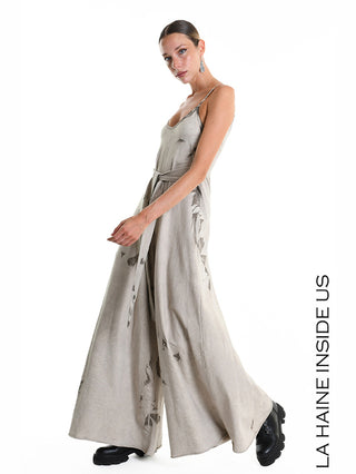 La Haine Jumpsuit W5296 Fango: Modell trägt einen weiten Palazzo-Jumpsuit mit Spaghettiträgern, Bindegürtel und subtilen Cut-out-Details, kombiniert mit schwarzen Plateau-Schnürschuhen.