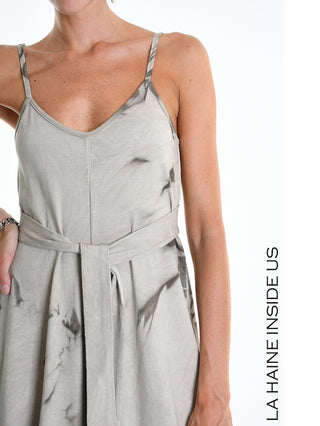 Die La Haine Jumpsuit W5296 Fango zeigt einen ärmellosen V-Ausschnitt mit dünnen Trägern und einem Stoffgürtel an der Taille, ideal für einen avantgardistischen Look.