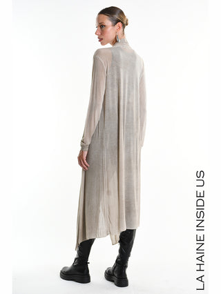 La Haine Cardigan W5324 Fango: Langer, asymmetrischer Cardigan in Beige, semi-transparent, mit fließendem Fall, kombiniert mit schwarzen kniehohen Stiefeln. Modell zeigt Profilansicht, Haare im tiefen Dutt.