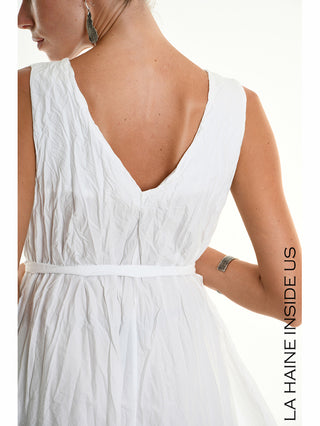 La Haine Dress 5378 white: Rück- und Seitenansicht eines ärmellosen weißen Kleids mit geknitterter Textur, V-Rückenausschnitt und Taillengürtel, getragen von einer Frau mit zurückgebundenem Haar und Schmuck.
