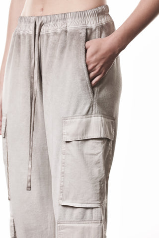 Thom Krom Hose WST 427 stone zeigt einen lässigen, leicht tiefer gesetzten Schnitt mit schmal zulaufendem Bein, elastischem Tunnelzugbund, texturierter Oberfläche und praktischen Cargo-Taschen, für einen urbanen Look.