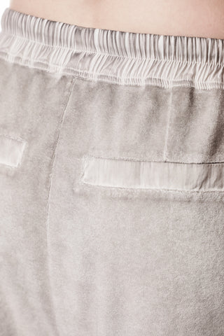 Thom Krom Hose WST 427 stone zeigt eine Nahaufnahme der Rückseite mit elastischem Bund und eingearbeiteten Taschen, gefertigt aus weichem, strukturiertem Terry-Stoff für modernen Avantgarde-Stil.