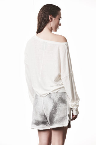 Thom Krom Tee WTS 613 offwhite: Locker geschnittenes, off-shoulder Shirt mit Bootsausschnitt und langen Ärmeln, das elegant-schlicht die Schultern betont, getragen mit grauen Shorts für einen entspannten Look.