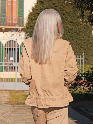 Eine Person trägt die OFF#DLY Jacke Lucie sand, eine locker geschnittene, leicht tanfarbene Jacke mit elastischem Bund, perfekt für entspannte Looks und Komfort.