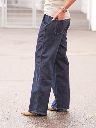 True Religion Lauren RAW Jeans mit weitem Bein, dunkelblauem Denim, klassischer Five-Pocket-Optik und authentischen Steppnähten. Kombiniert mit beigen spitzen Schuhen, ideal für einen modernen, selbstbewussten Look.