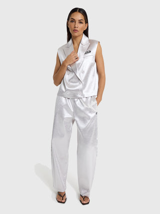 Frau trägt ALIX Woven Shiny Pant silver mit metallischem Glanz. Die Hose hat einen modernen Barrel Fit, ist locker geschnitten und bietet elegantes Aussehen mit komfortablem, elastischem Bund.